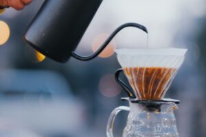 Apă turnată dintr-un fierbător cu gât de lebădă într-un dripper V60