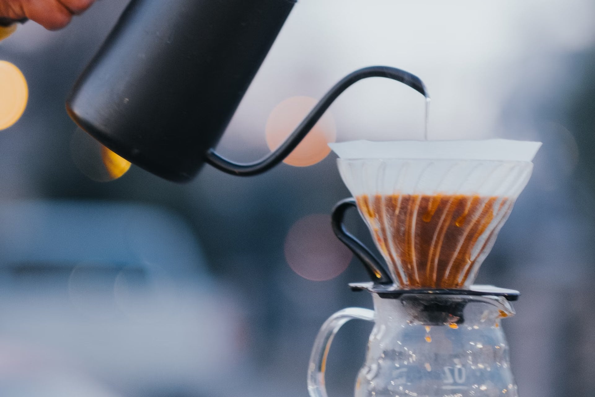 Apă turnată dintr-un fierbător cu gât de lebădă într-un dripper V60